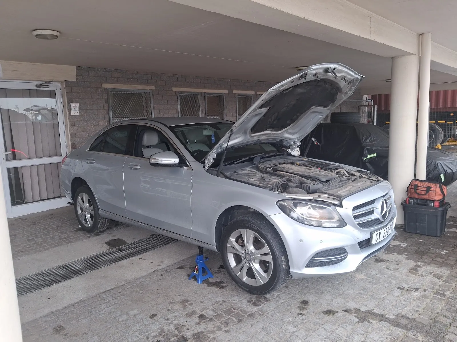 Mercedes-Benz C-Class raised on jack stands for on-site service